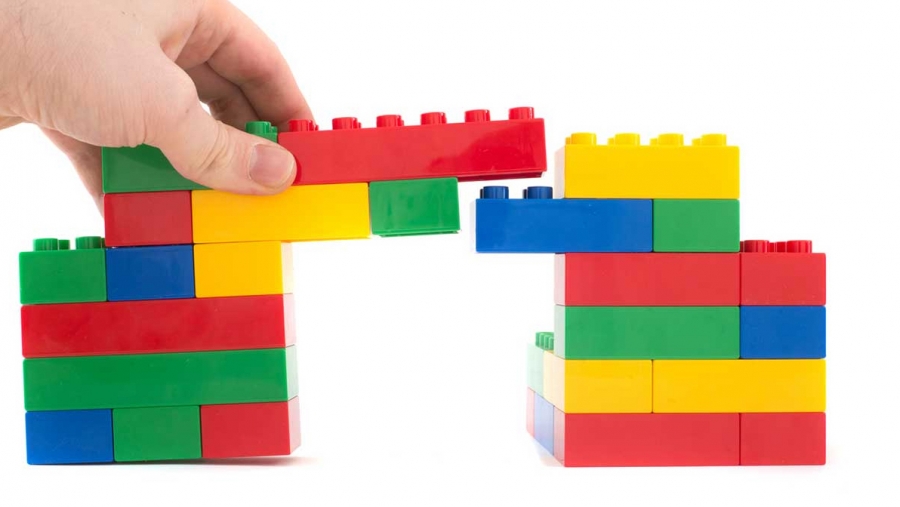 hand building a colorful bridge made out of toy blocks